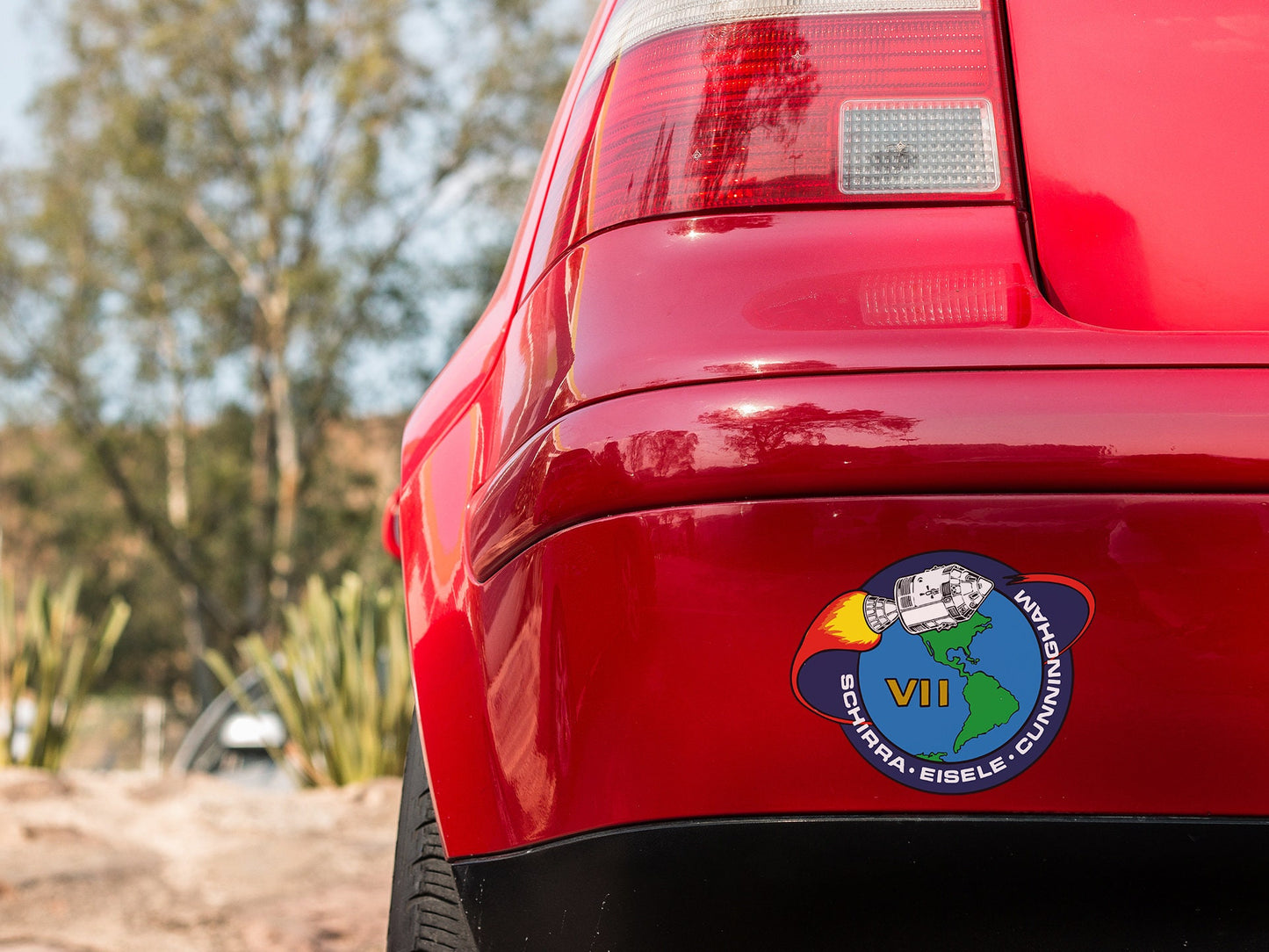 a close up of a red car with a sticker on it