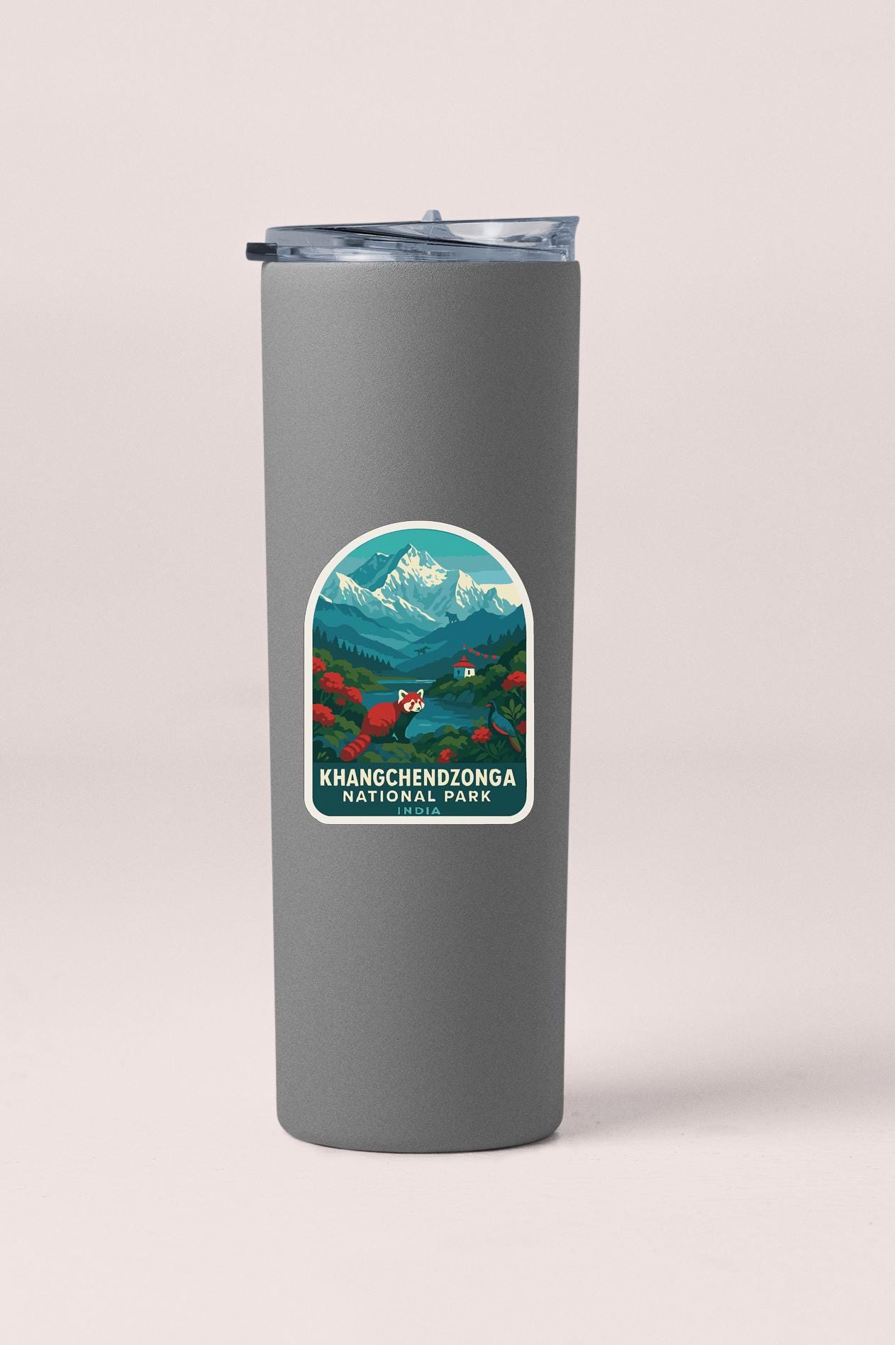 A gray tumbler with a sticker depicting a mountain landscape and the text "KHANGCHENZONGA NATIONAL PARK".