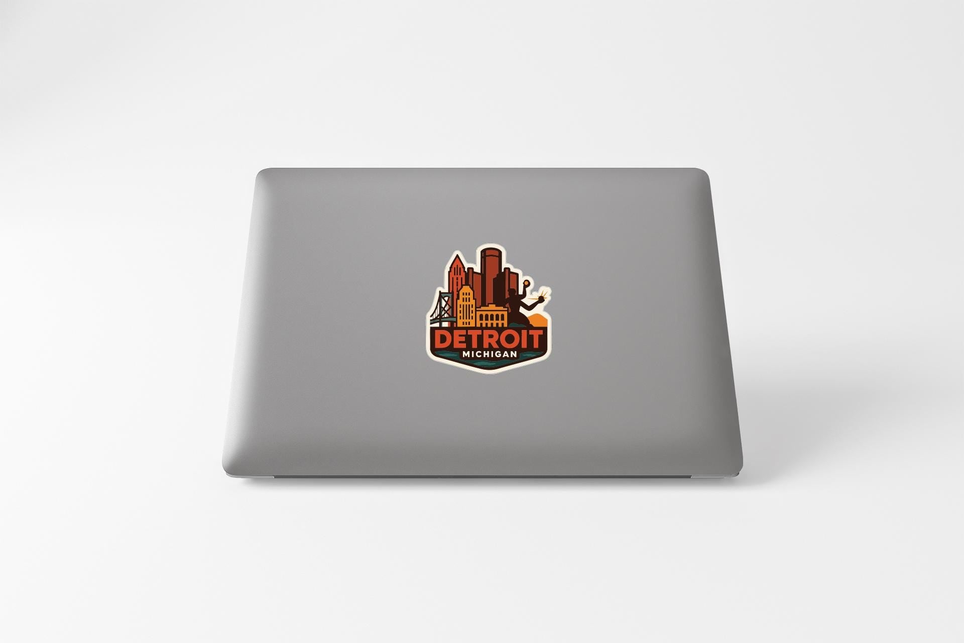 A sticker featuring the city of Detroit, Michigan, with various landmarks and buildings depicted in a stylized manner.