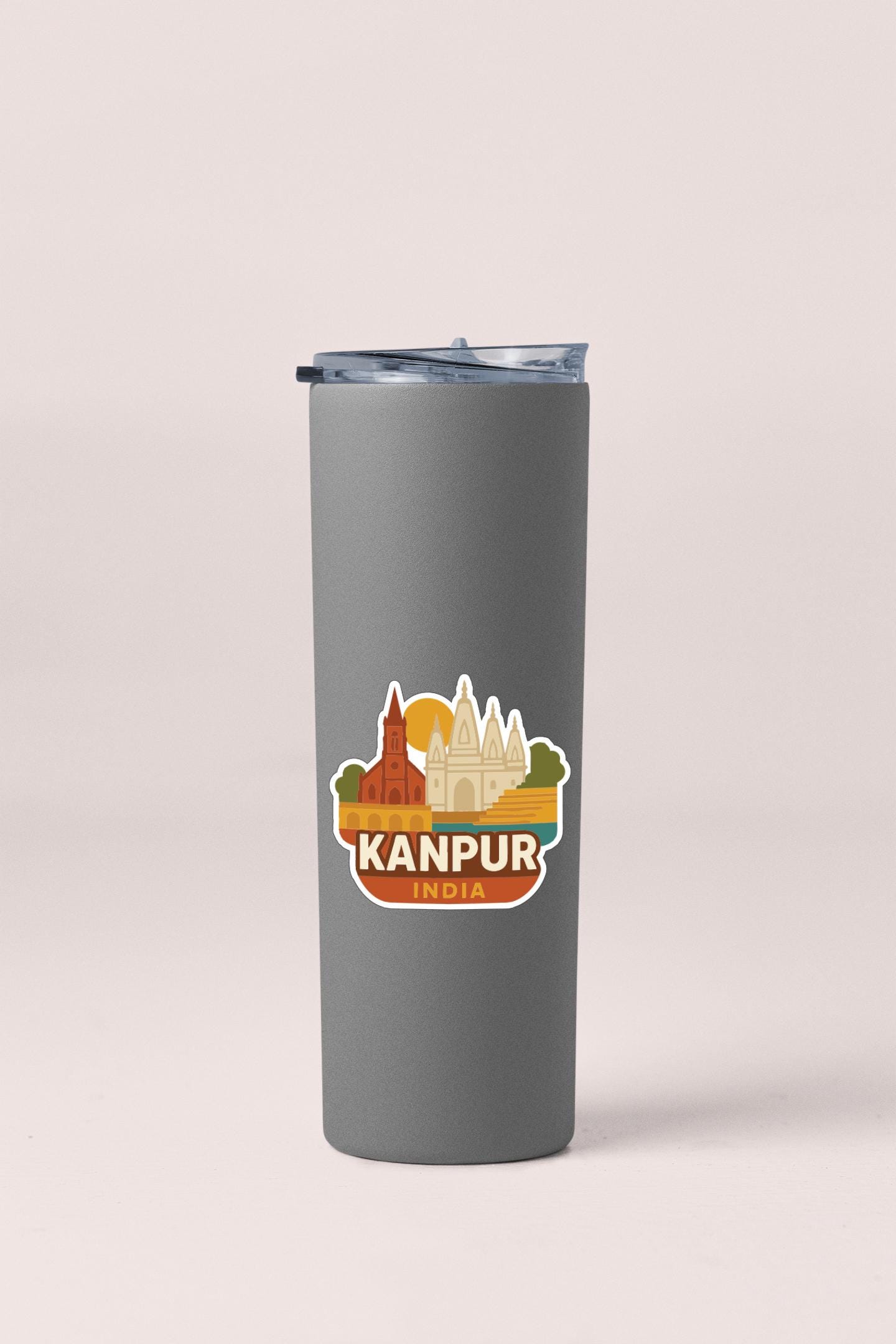 A gray tumbler with a sticker depicting the skyline of Kanpur, India.