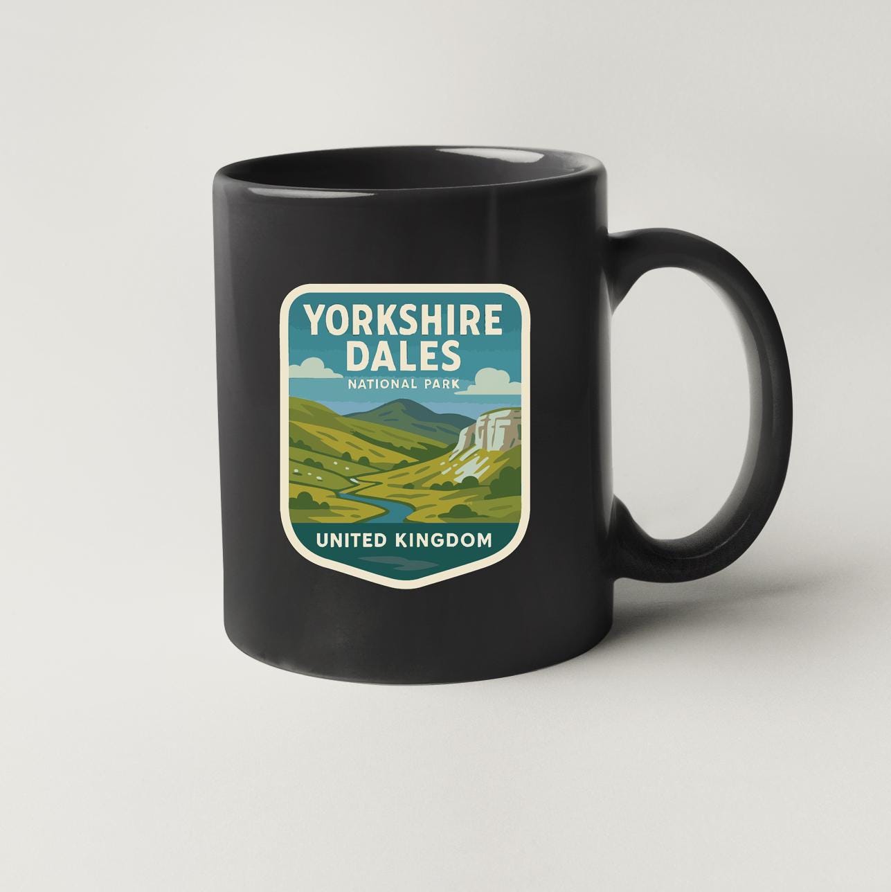A black coffee mug with a graphic design depicting Yorkshire Dales National Park in the United Kingdom.