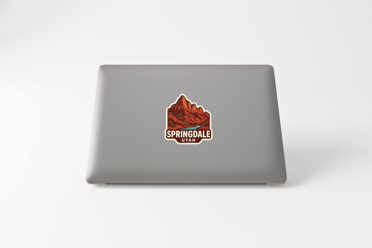 A sticker on the back of a laptop displaying the text "SPRINGdale Utah" along with an illustration of a mountain landscape.