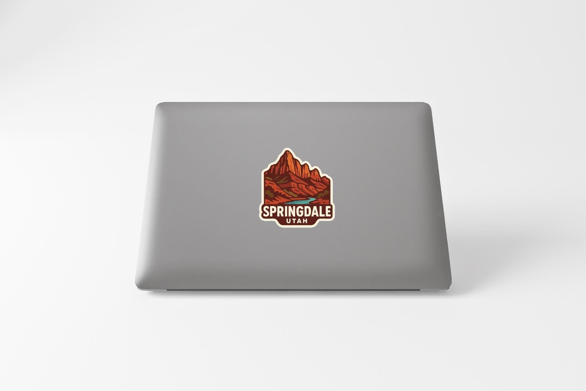 A sticker on the back of a laptop displaying the text "SPRINGdale Utah" along with an illustration of a mountain landscape.