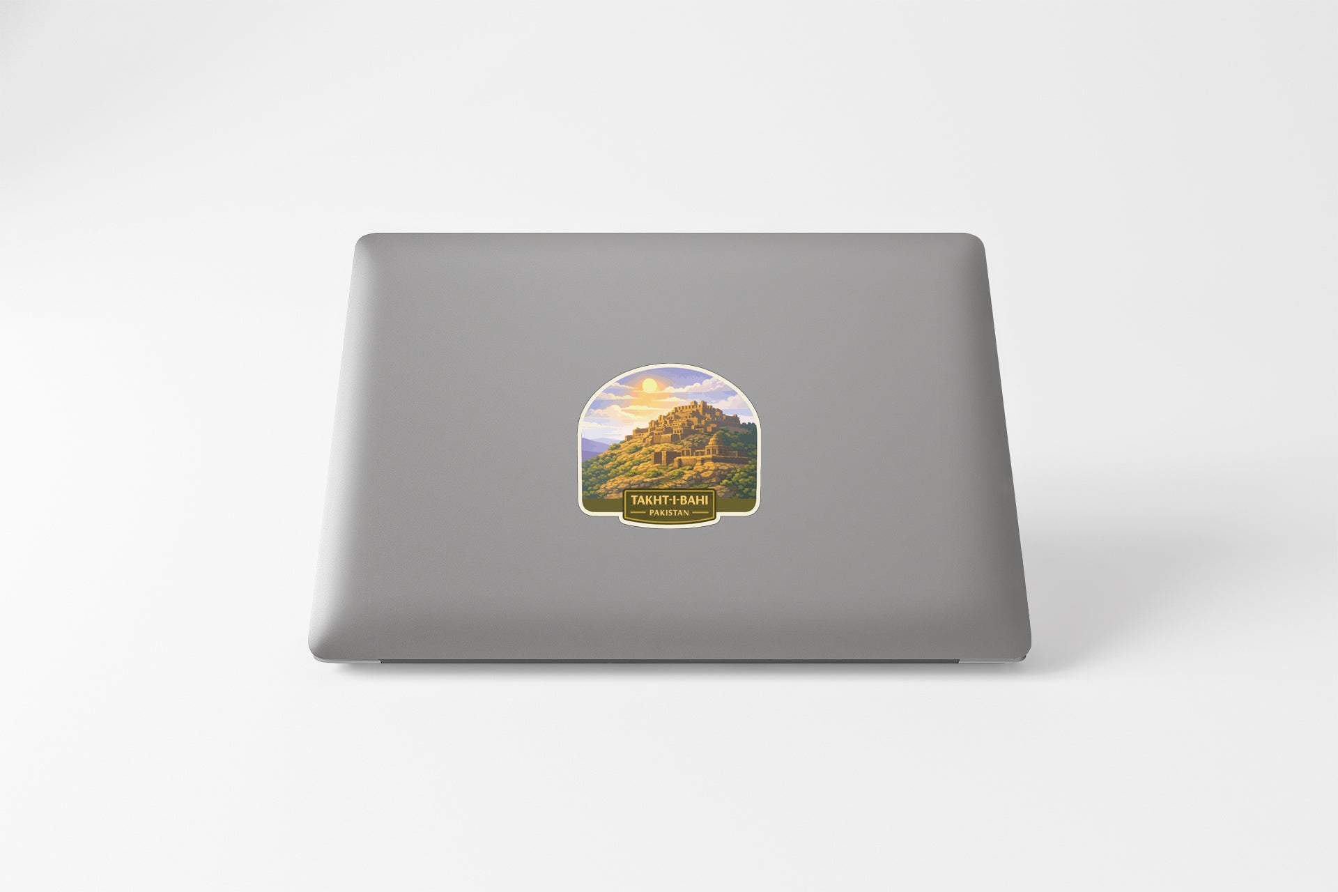 A sticker depicting a mountain landscape is placed on the back of a laptop computer.
