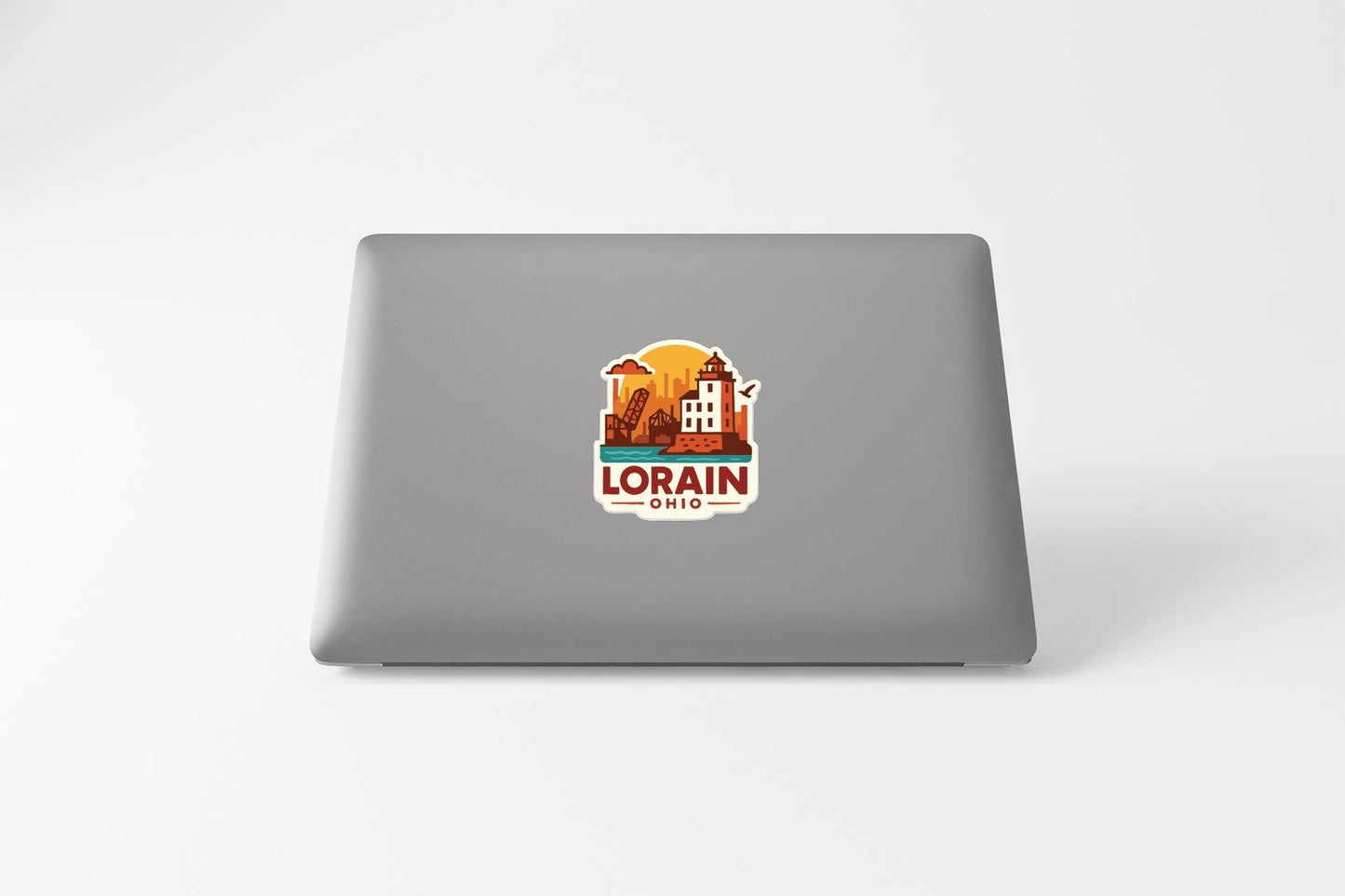 a sticker with a graphic of a building and the text "LORAIN, OHIO" on the back of a laptop.