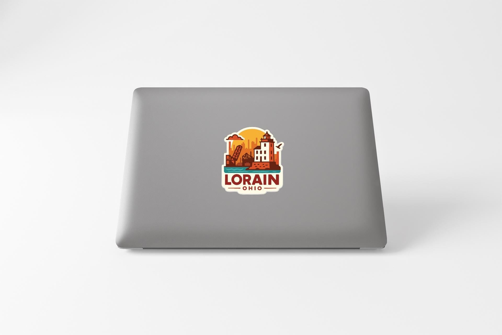 a sticker with a graphic of a building and the text "LORAIN, OHIO" on the back of a laptop.