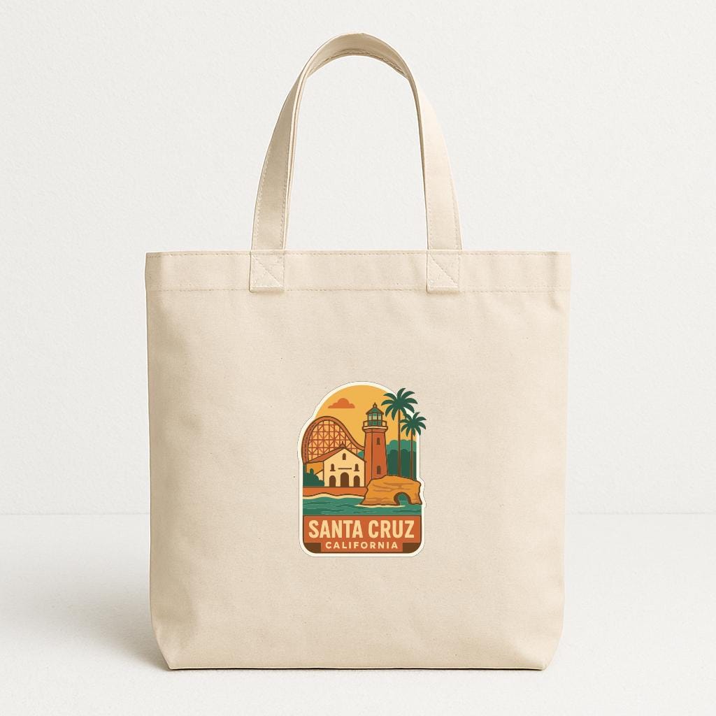 A beige tote bag with a printed design of Santa Cruz, California, featuring a lighthouse, palm trees, and a bridge.