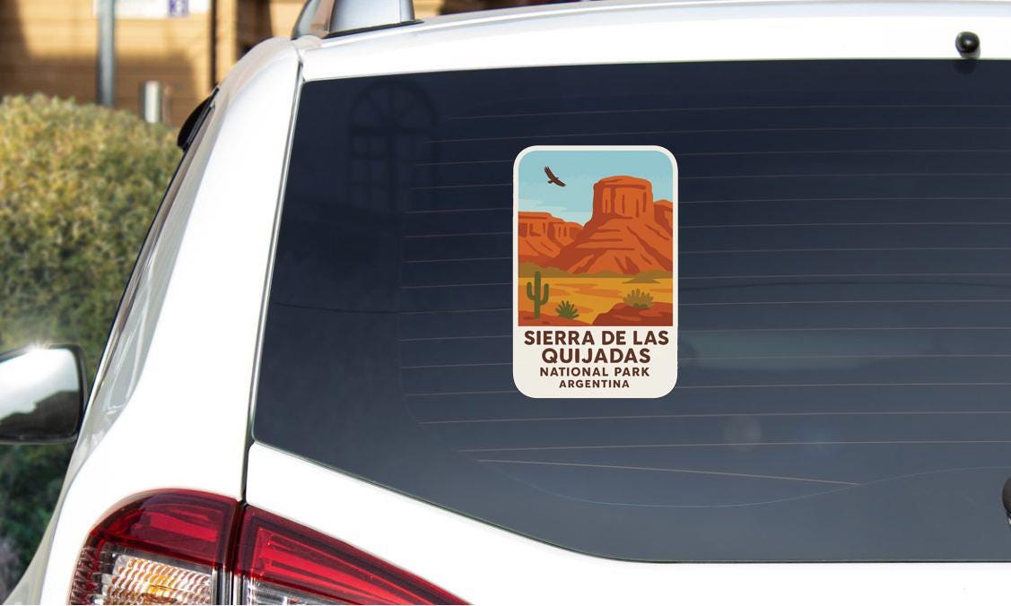 a sticker on the rear window of a car, depicting a desert landscape with mountains and a bird in flight.
