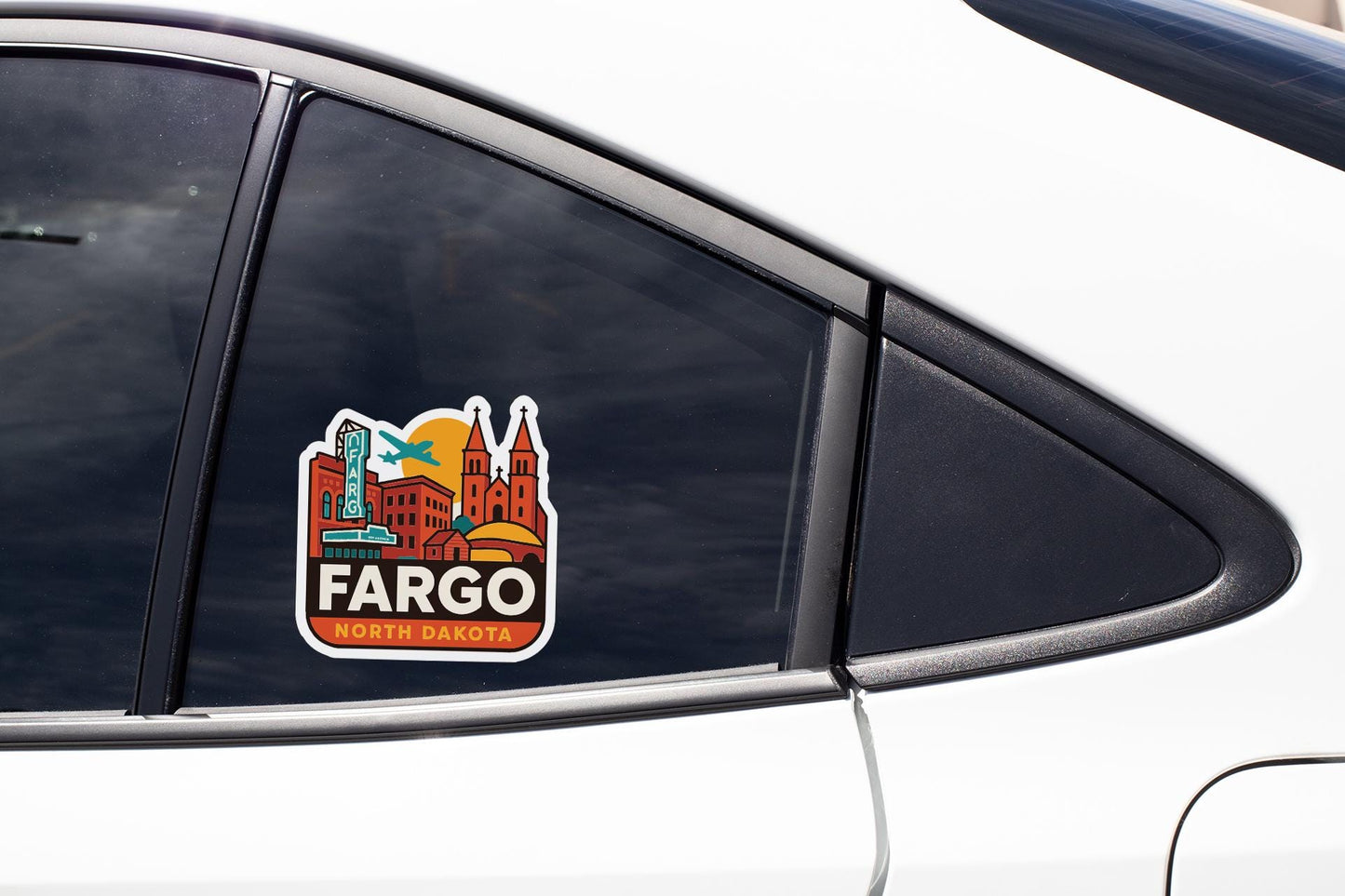 A sticker on the side of a car window, featuring a colorful illustration of a city skyline with the word "Fargo" prominently displayed.