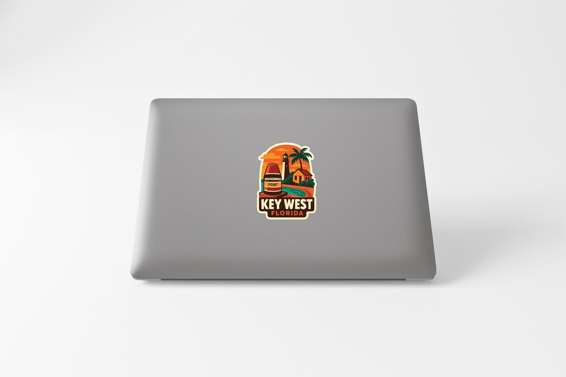 a sticker with a tropical beach scene and the text "KEY WEST FLORIDA" printed on a laptop.