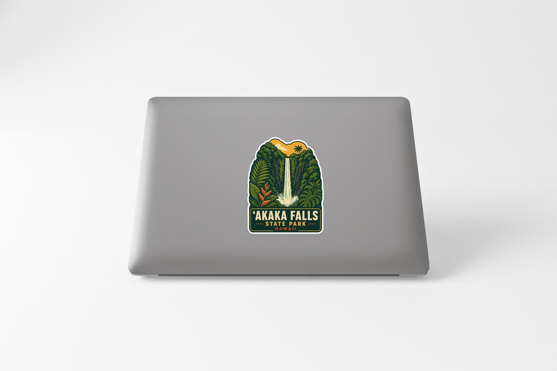 A sticker on the back of a laptop, depicting a waterfall surrounded by lush greenery.
