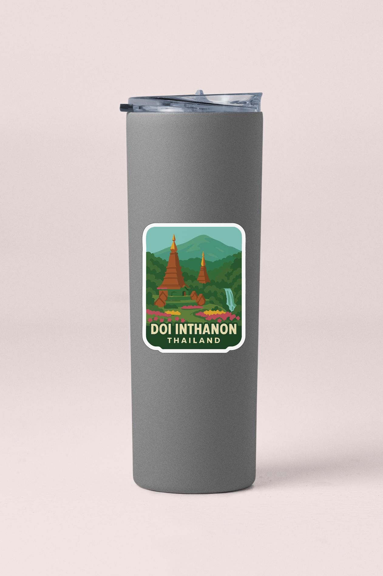 A gray tumbler with a sticker depicting the Doi Inthanon temple in Thailand.