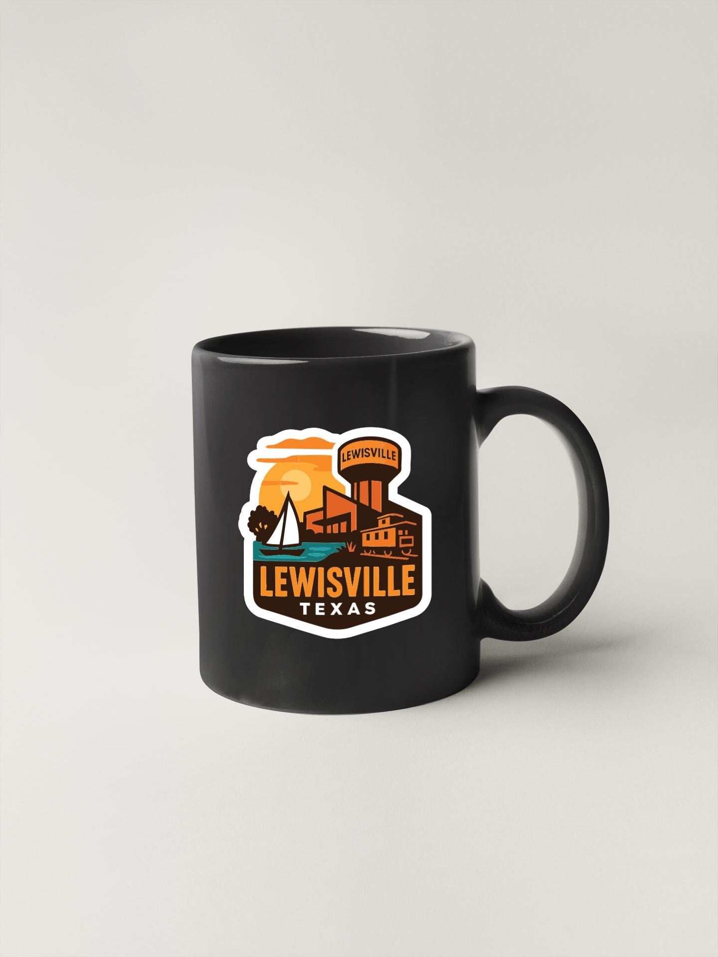 A black coffee mug with a colorful sticker depicting the city of Lewisville, Texas.