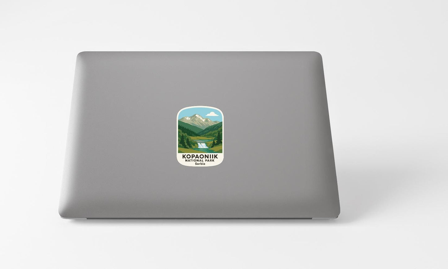 A sticker with a mountain landscape and the text "KOPANIK NATIONAL PARK" printed on a grey laptop.