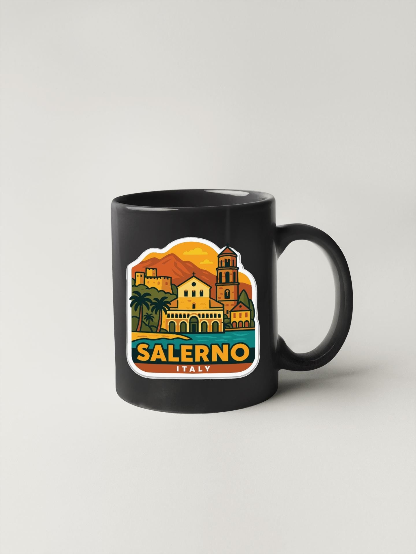 A black coffee mug with a colorful illustration of the town of Salerno, Italy, featuring buildings, palm trees, and mountains.