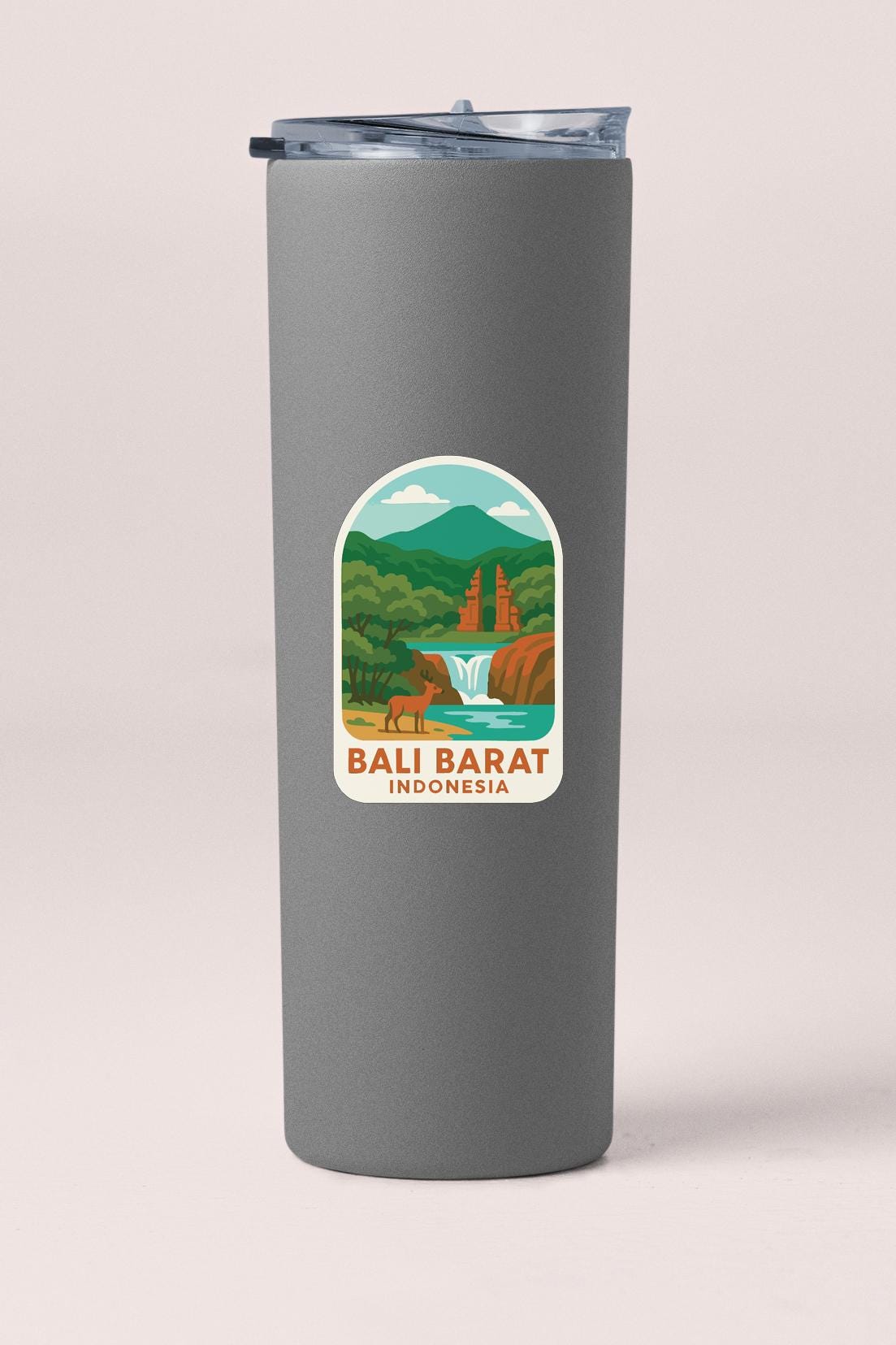 A gray tumbler with a sticker depicting a scenic landscape featuring a waterfall, mountains, and a temple.