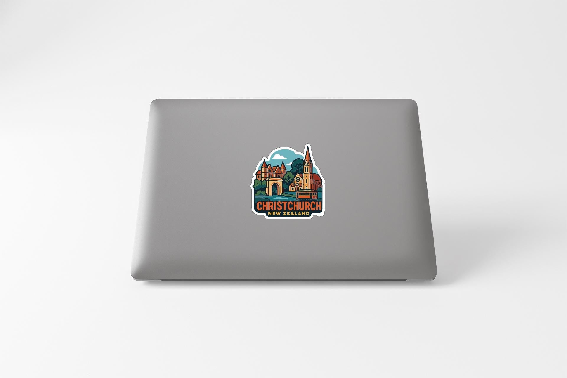 A sticker on the back of a laptop displaying a colorful illustration of a church and surrounding buildings.
