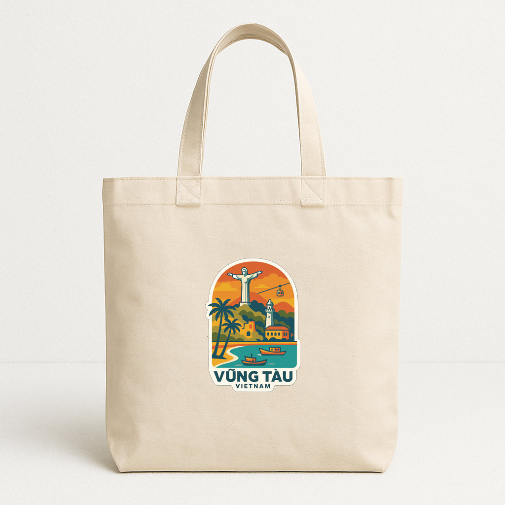 A beige tote bag with a printed design depicting a tropical landscape and landmarks, including a large statue of Christ and a lighthouse.