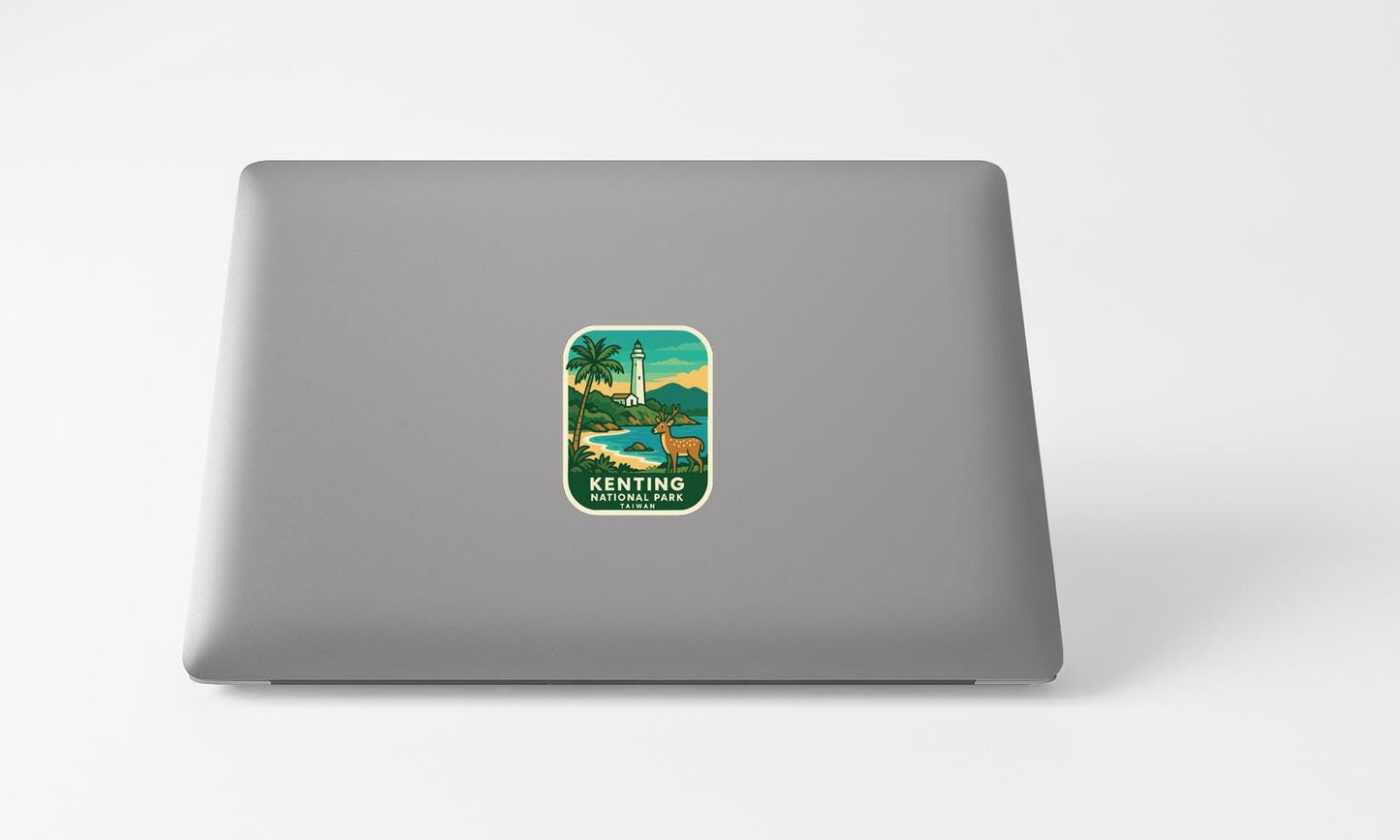 A sticker on the back of a laptop, depicting a tropical landscape with a lighthouse and palm trees.