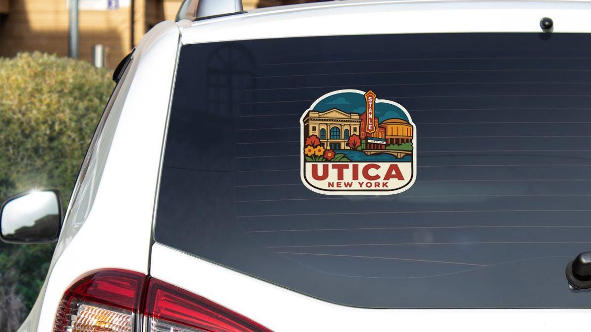 a sticker on the rear window of a white car, depicting a scenic view of Utica, New York.