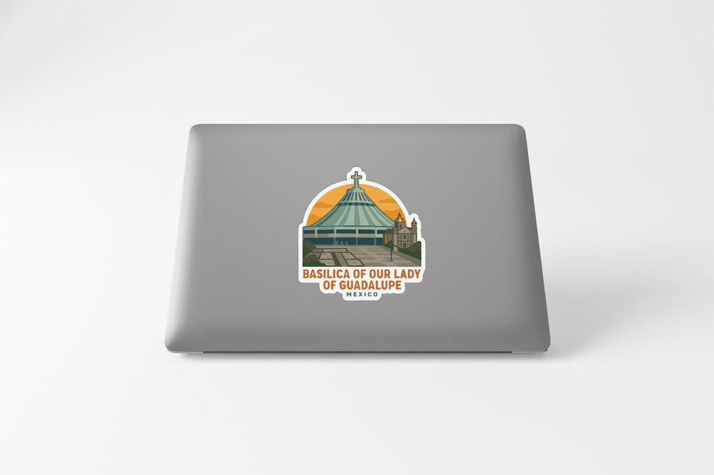 a sticker on a laptop that depicts a church with a dome and a cross, along with the text "BASILICA OF OUR LADY OF GUADALUPE MEXICO".