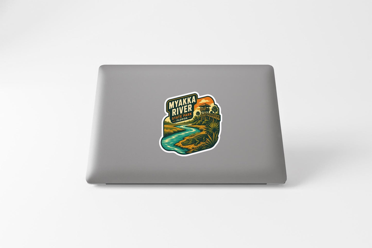 A sticker depicting a scenic view of the Myakka River, with a sunset and landscape in the background.