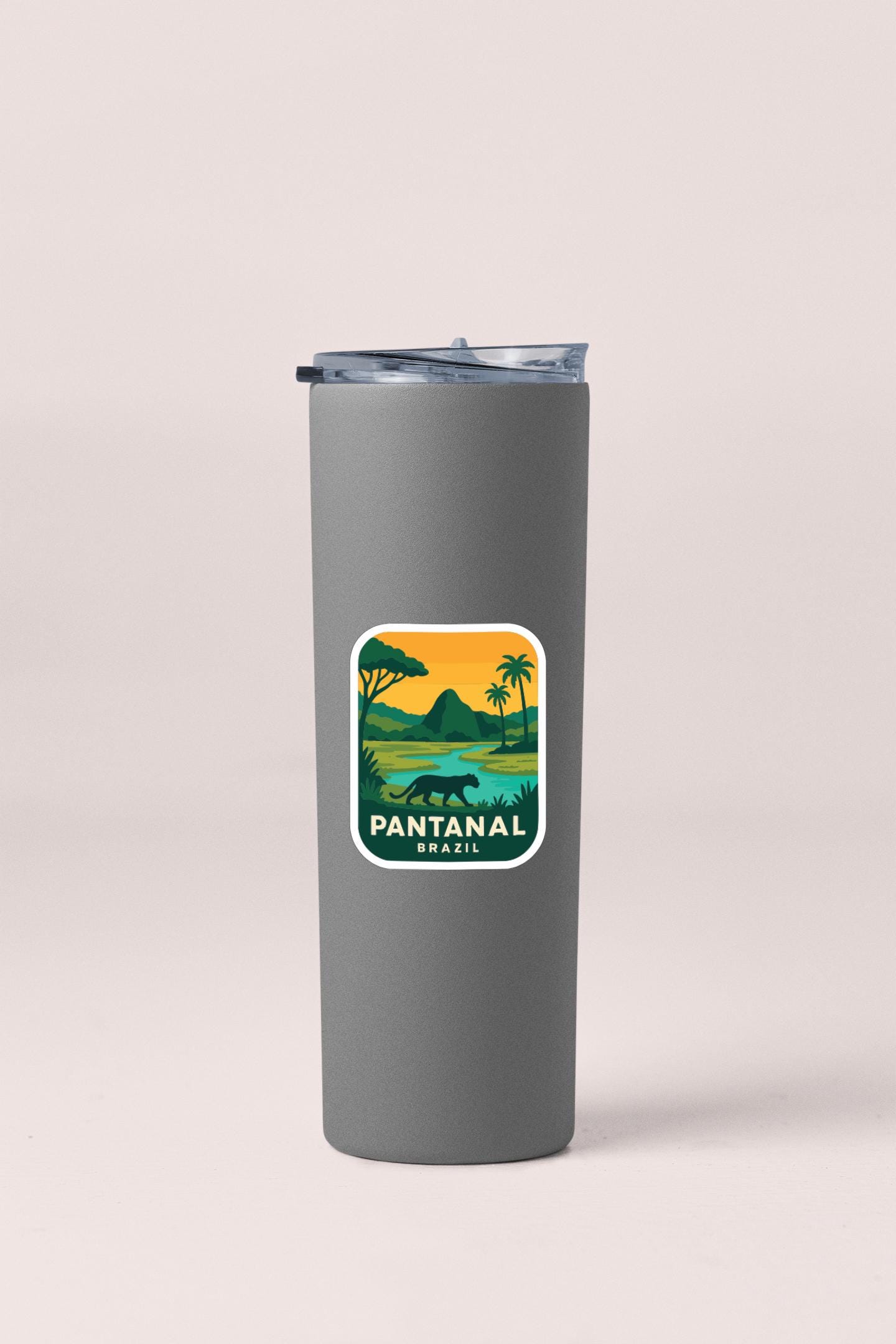 A gray insulated tumbler with a sticker depicting a tropical landscape and the text "PANTANAL BRASIL".