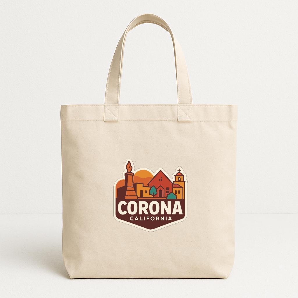 A beige tote bag with a graphic design featuring a cityscape and the text "CORONA CALIFORNIA" printed on it.