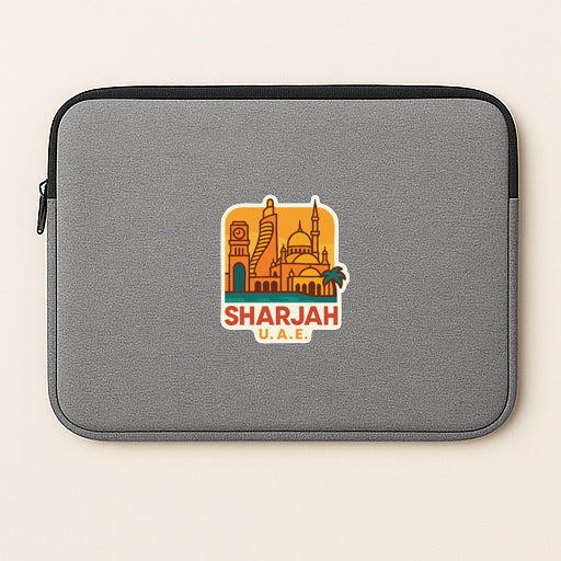 A gray laptop sleeve with a sticker of the skyline of Sharjah, United Arab Emirates.