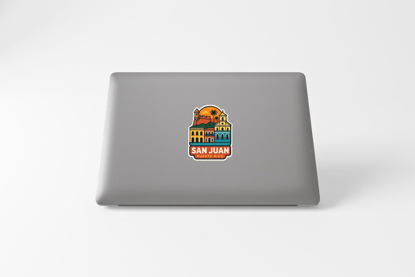 a sticker with a colorful illustration of a building and a palm tree, along with the text "SAN JUAN" and "TO RICO".