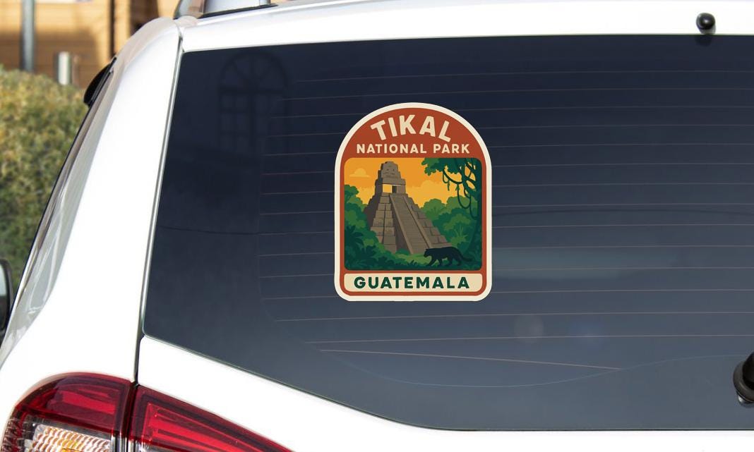 A sticker on the rear window of a car that says "Tikal National Park Guatemala".