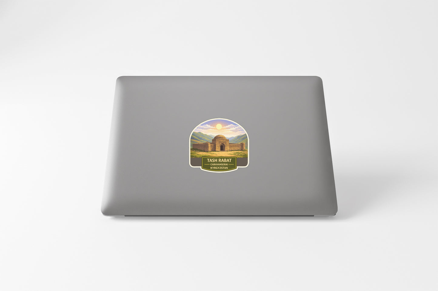 a sticker with a picture of a building and text, placed on the back of a laptop.