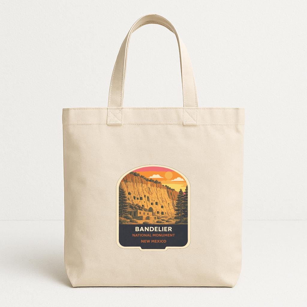 A beige tote bag with a printed label that says "BANDELIER NATIONAL ARCHITECTURE NEW MEXICO".