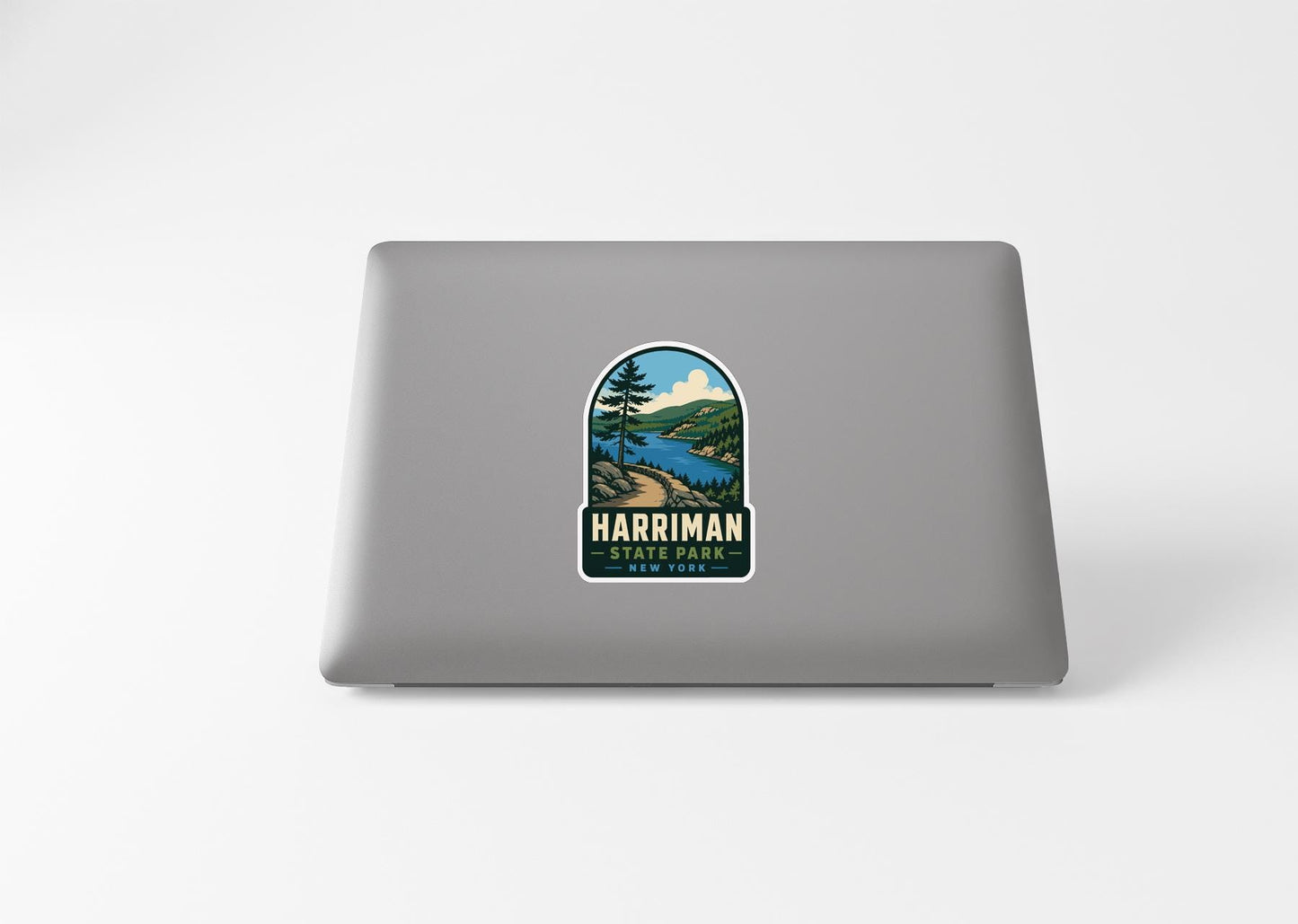 A sticker on the back of a laptop, depicting a scenic landscape with a lake and mountains.