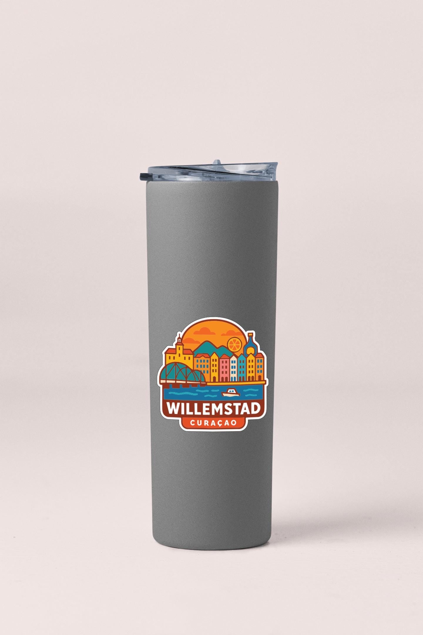 A gray insulated tumbler with a sticker depicting a city skyline and the text "WILLEMSTAD CURAGAC" printed on it.