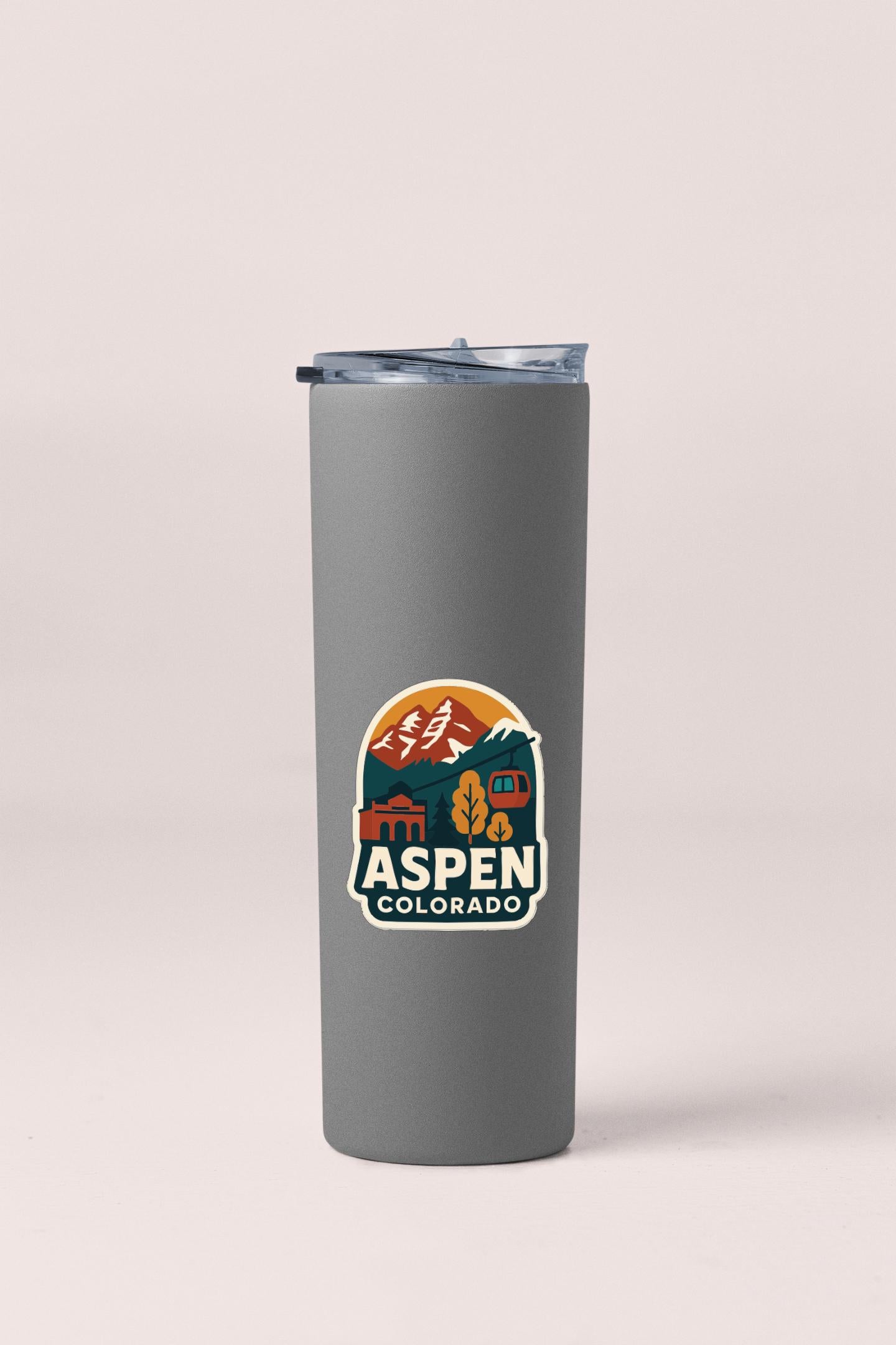 A gray insulated tumbler with a lid and a sticker featuring a mountain landscape and the text "Aspen, Colorado".