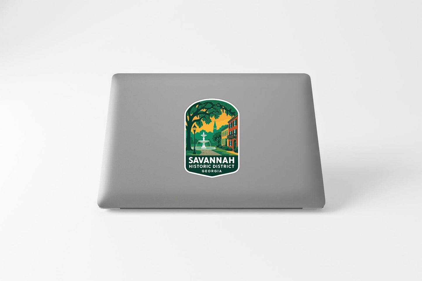 a sticker with a graphic of a street and buildings, along with the text "SAVANNAH HISTORIC DISTRICT" printed on it.