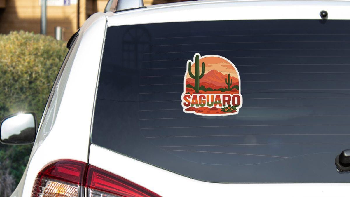 the rear window of a white car with a sticker on it.