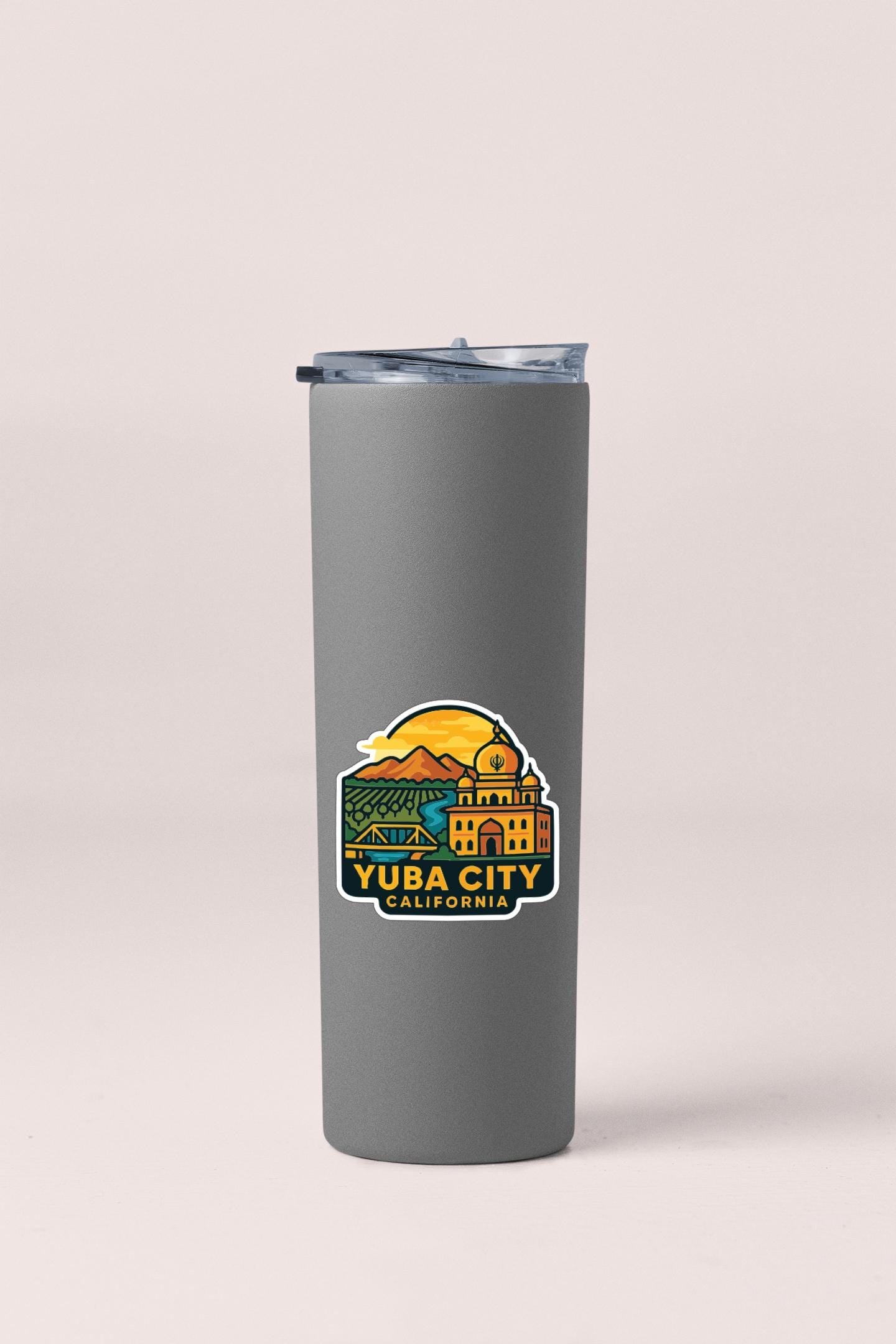 A gray insulated tumbler with a sticker depicting the city of Yuba City, California.