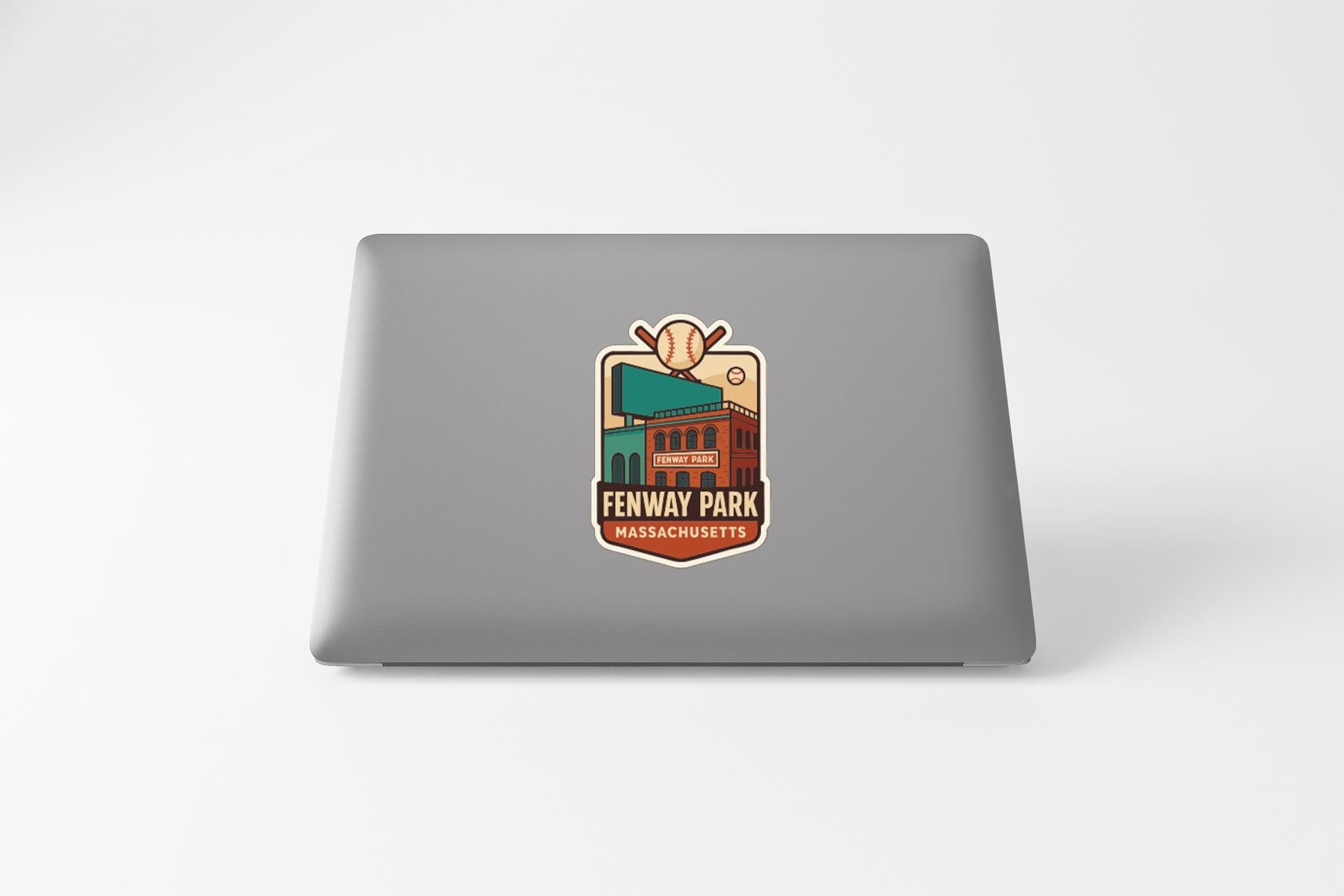 a sticker on the back of a laptop that displays the name "FENWAY PARK" and "MASSACHUSETTS", along with a baseball and a building.