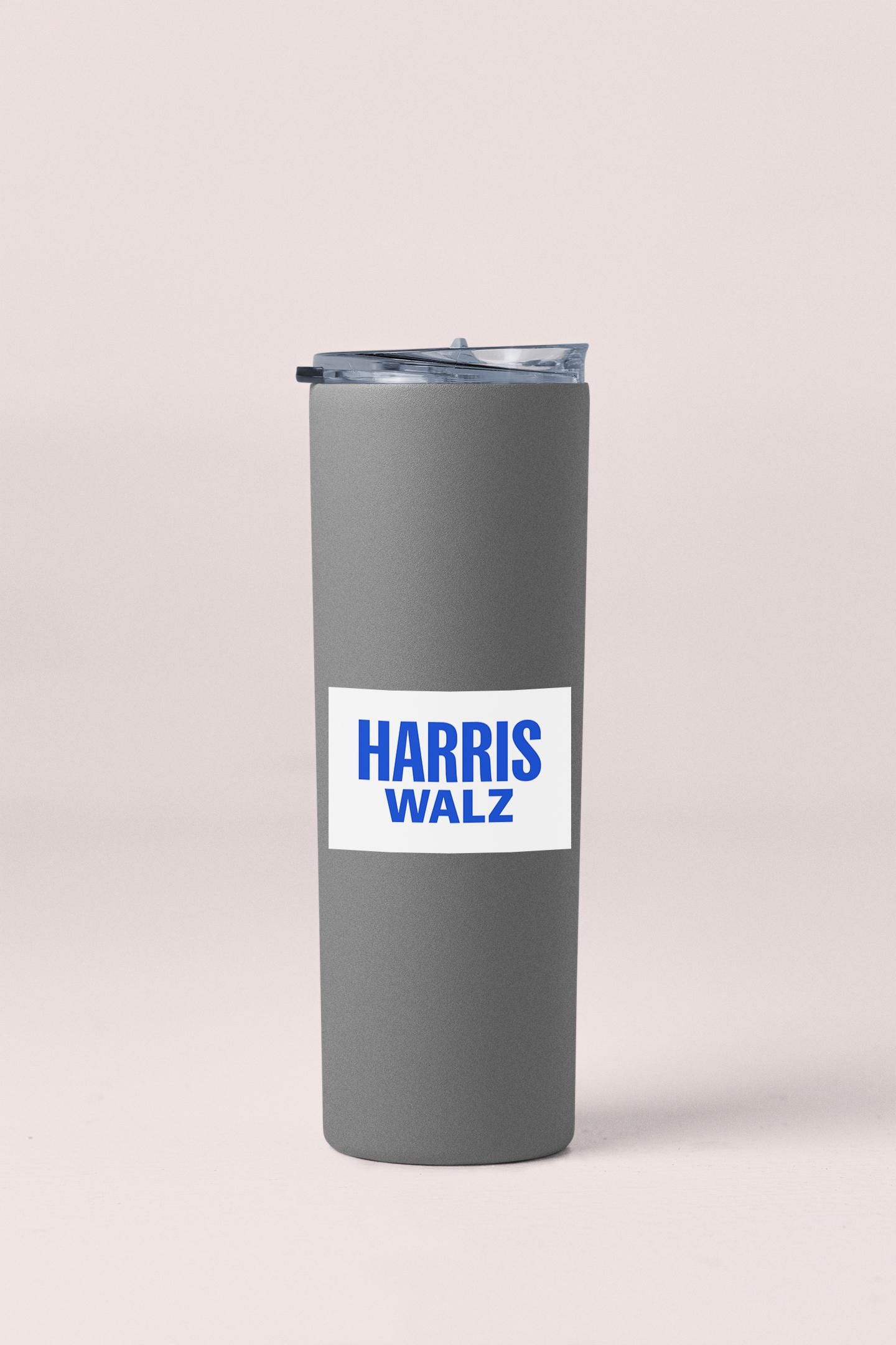 a gray tumbler with a blue sticker on it