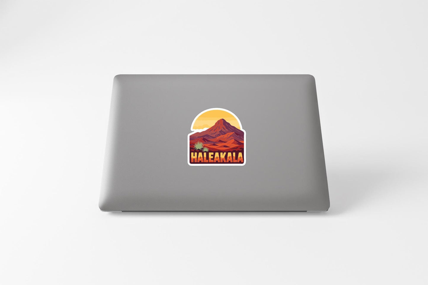 A sticker with a mountain landscape and the word "Haleakala" printed on a laptop.