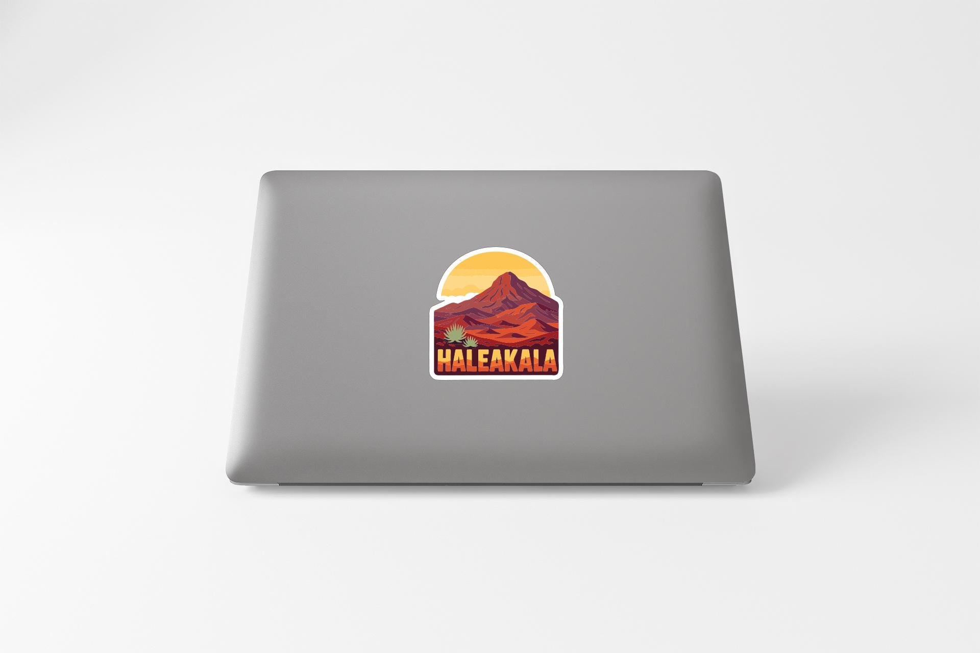 A sticker with a mountain landscape and the word "Haleakala" printed on a laptop.