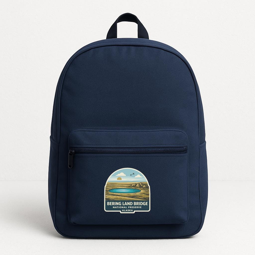 A navy blue backpack with a sticker on the front that says "BERING LANE BRIDGE NATIONAL PARK AND HILLSIDE ALASKA".