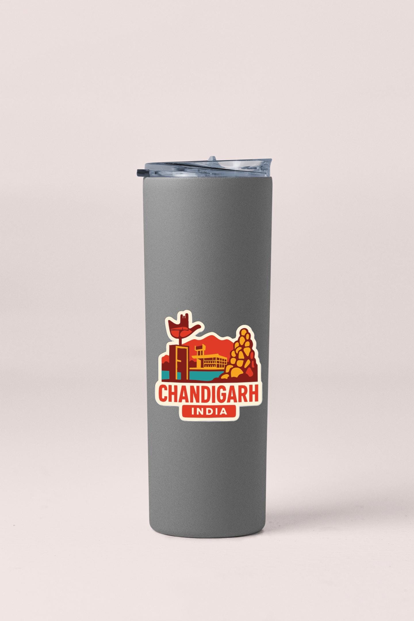 A gray insulated tumbler with a sticker depicting a cityscape and the text "CHANDIGARh INDIA" printed on it.