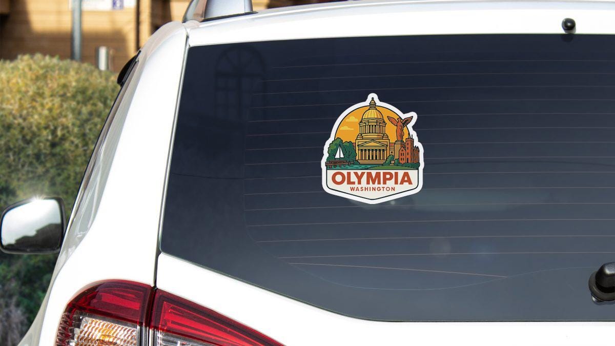 A sticker on the rear window of a white car, depicting the Capitol Building and the city of Olympia, Washington.