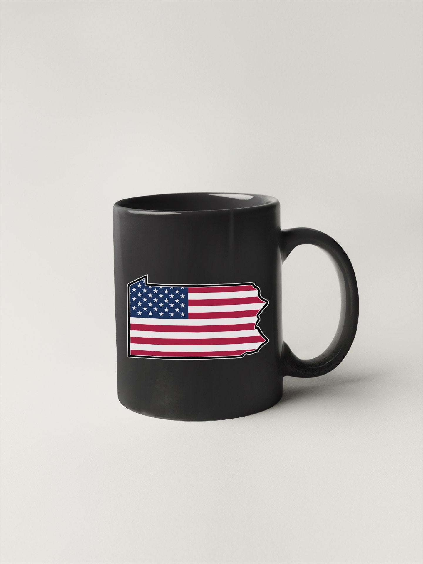 a black coffee mug with an american flag on it