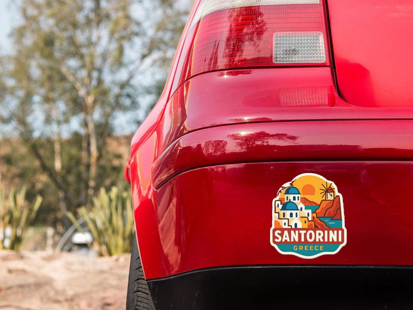 the rear end of a red car with a sticker on the trunk that says "SANTORINI GREECE".