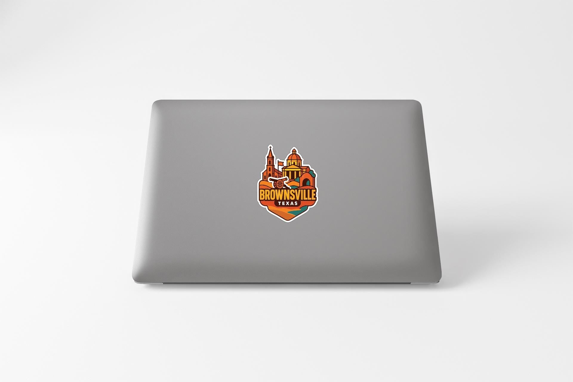 A sticker on the back of a laptop, featuring an illustration of a building and the text "Brownsville, Texas".