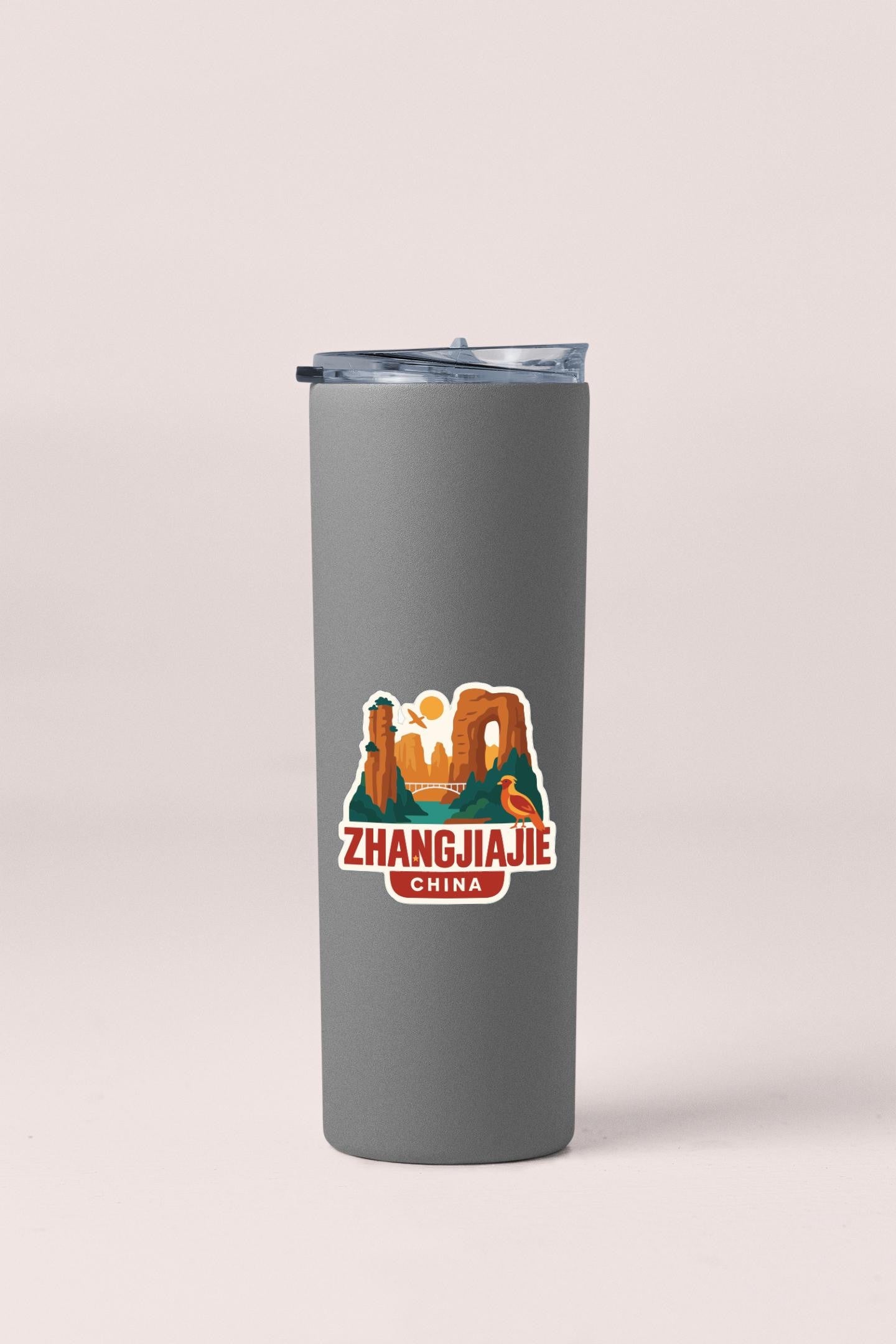 A gray insulated tumbler with a sticker depicting a scenic landscape and the text "Zhangjiajie China".